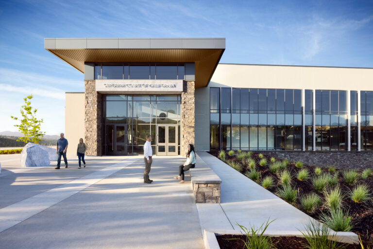 Modern Superior Court of California building with glass facade, stone columns, and people outside on the plaza