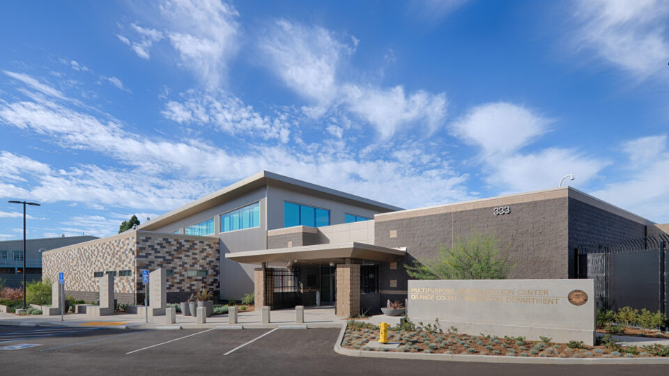 Exterior of the Multipurpose Rehabilitation Center, Orange County Probation Department, with parking lot and blue sky.