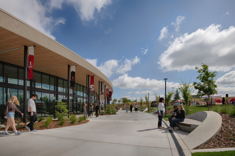 Students walking and sitting outside a modern Sierra College building on a sunny day.
