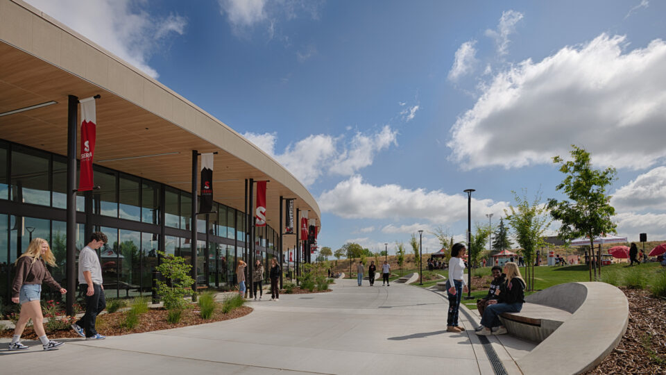 Students walking and sitting outside a modern Sierra College building on a sunny day.