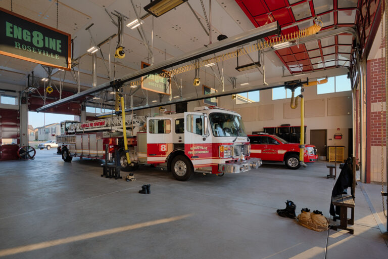 Roseville Fire Department ladder truck and SUV parked inside Engine 8 fire station garage.