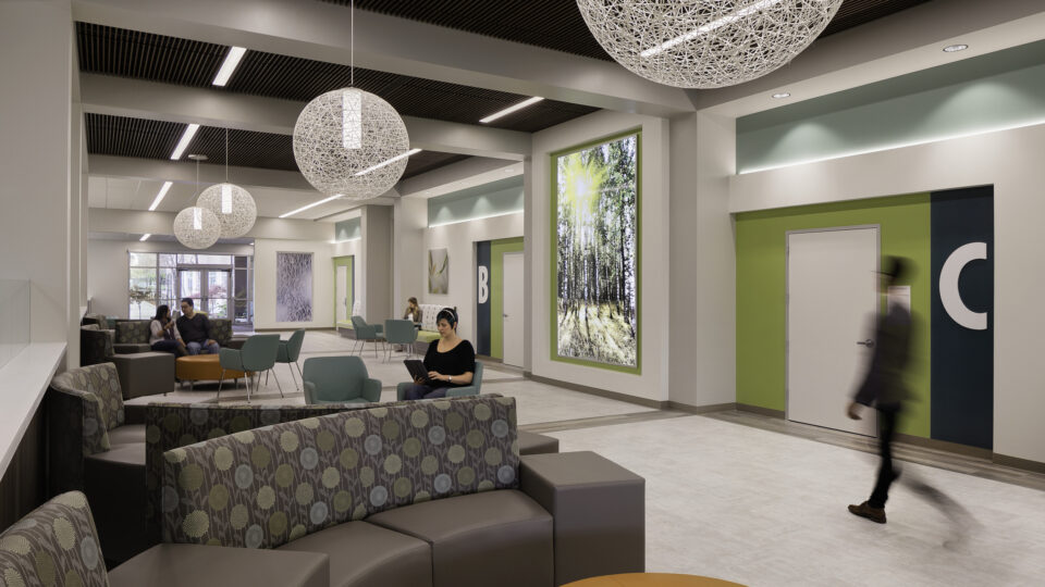 Modern lobby seating area with pendant lights, colorful walls, and people sitting and walking through the space
