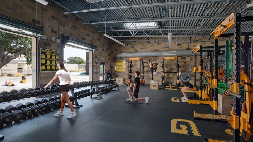 People exercising in a weight room with dumbbells, squat racks, and plyometric box jumps