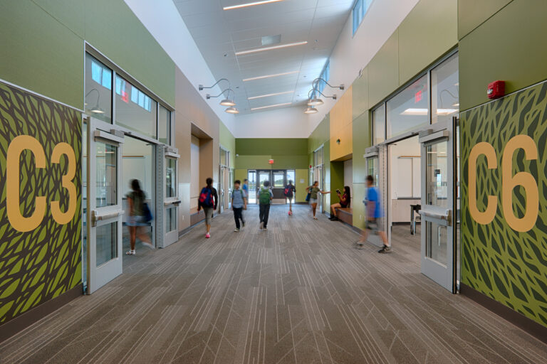 Modern school hallway with students walking past classroom doors marked 3C3 and C6