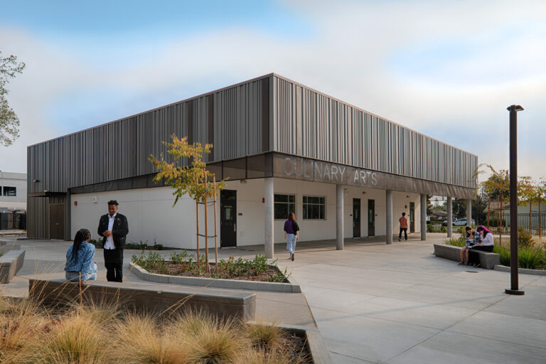 Modern campus building labeled Culinary Arts with students sitting and walking outside on a courtyard plaza