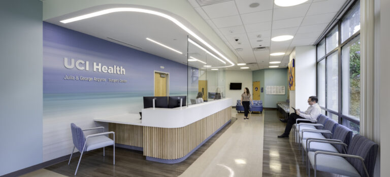 Bright medical reception area with UCI Health Surgery Center signage, waiting chairs, and a receptionist desk