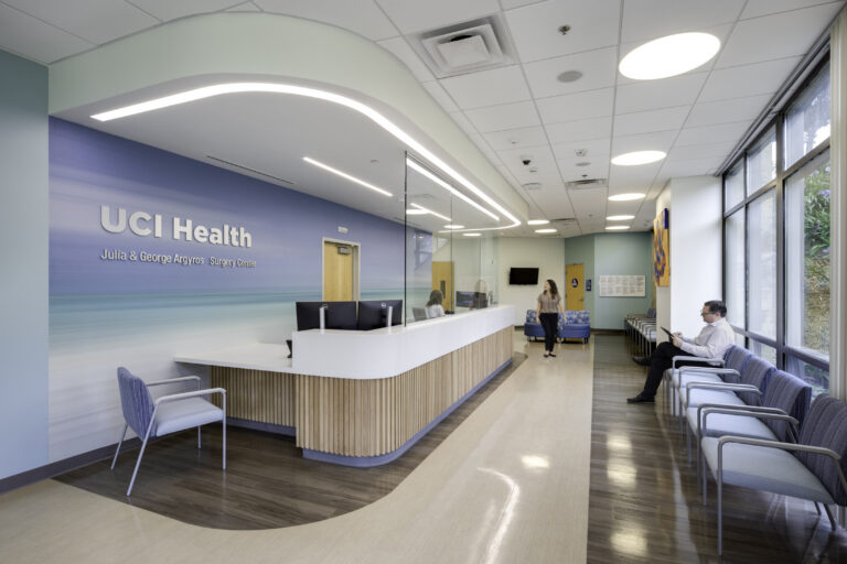 Bright medical reception area with UCI Health Surgery Center signage, waiting chairs, and a receptionist desk