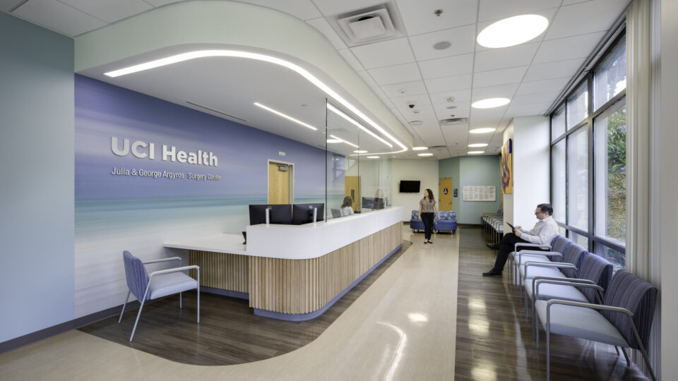 Bright medical reception area with UCI Health Surgery Center signage, waiting chairs, and a receptionist desk