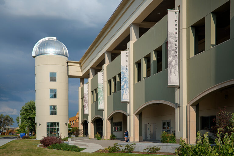 University building with a domed tower and vertical banners for microbiology, physics, physiology, and zoology