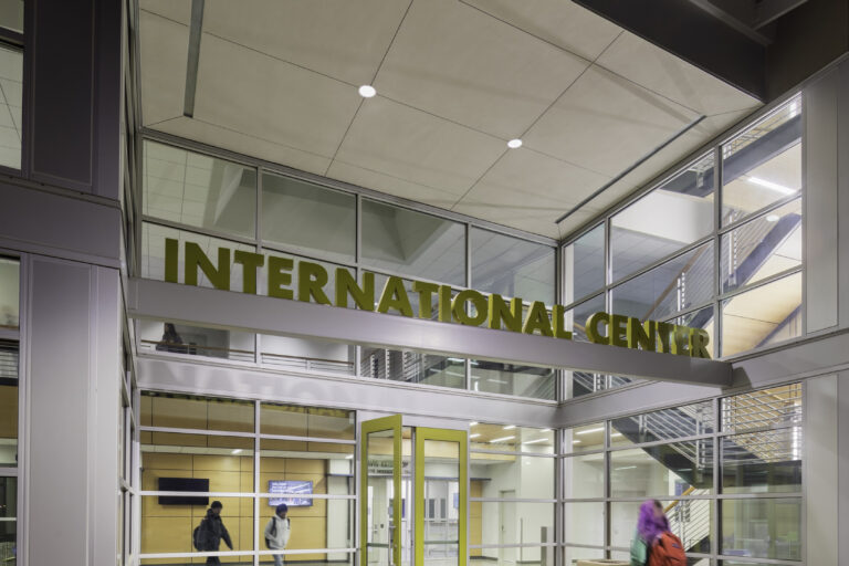 Modern glass entrance labeled INTERNATIONAL CENTER with students walking inside