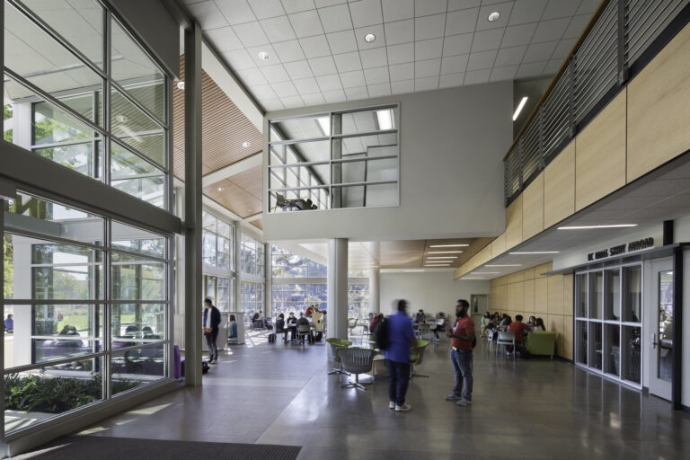 Modern university lobby with large windows, students sitting and talking, and a UC Davis Study Abroad office sign